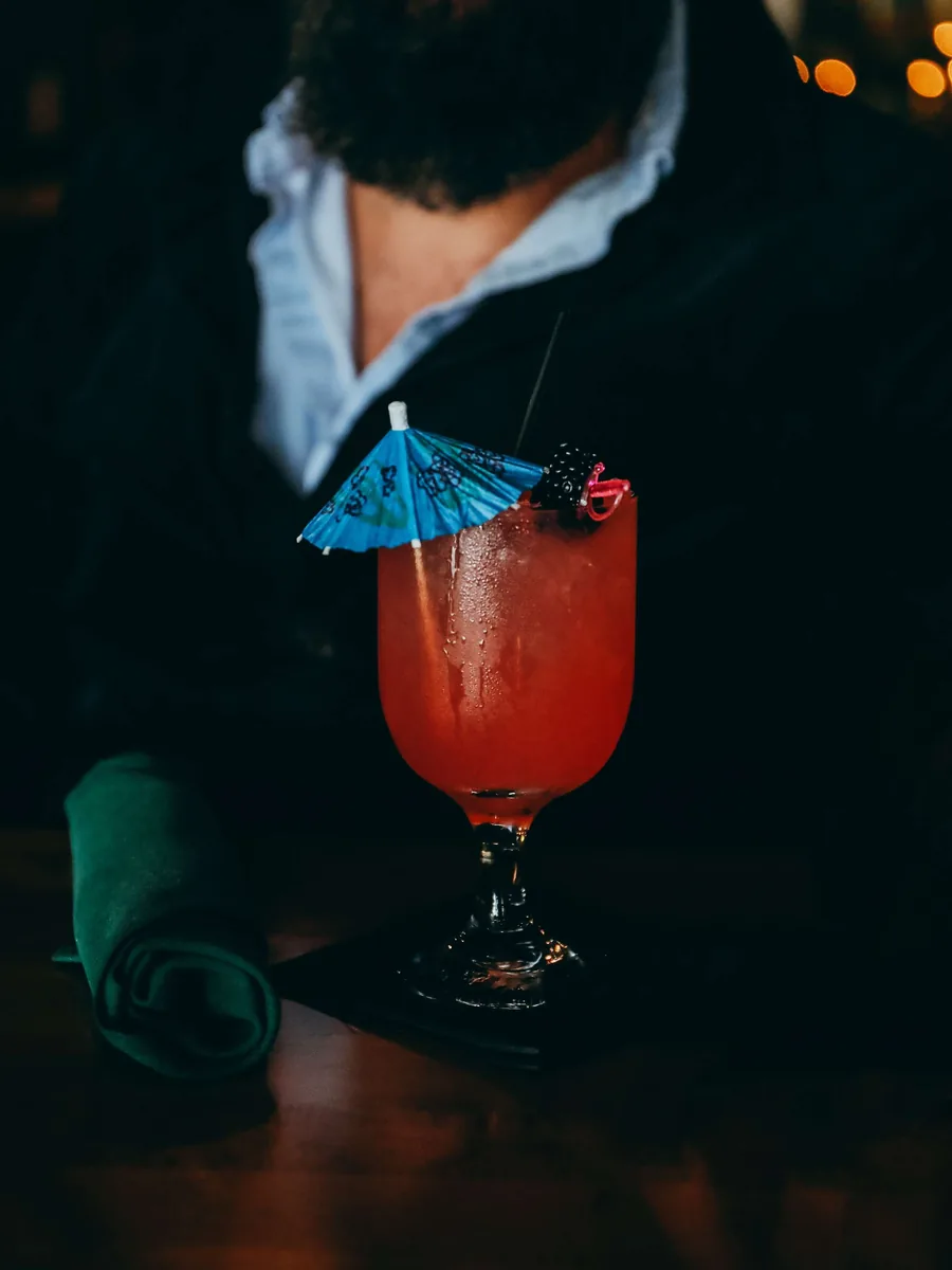 A colorful house cocktail served tableside